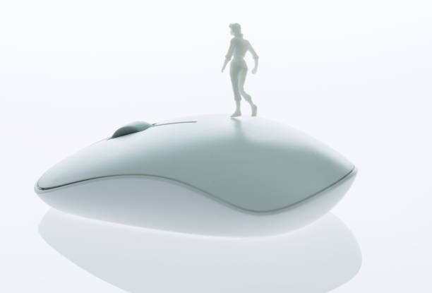 istock Woman figurine standing on computer mouse 1057116398