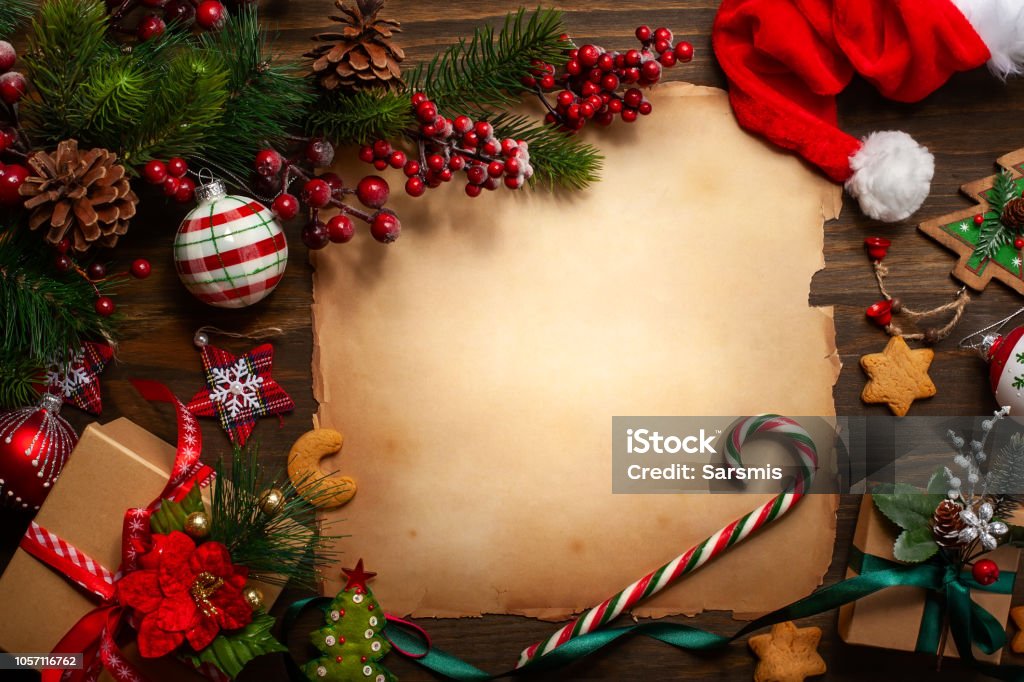 holiday Frame with vintage paper, fir branches, cookies and Christmas decorations on dark wooden background. Letter to Santa Claus. Top view. Christmas Stock Photo