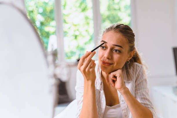 istock woman using make up at her home 1057120068