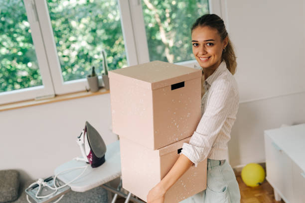 istock Woman holding cardboard boxes in her apartment 1057120876