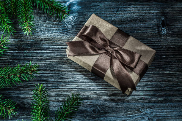 istock Brown present box pine branches on vintage wooden board 1057129018