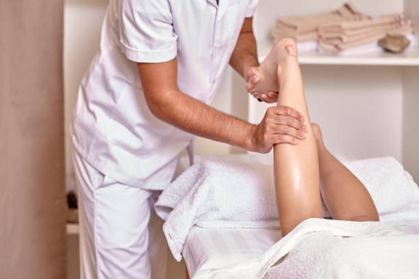 istock two people, man physiotherapist leg massage, close up. 1057129062