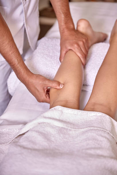 istock two people, man physiotherapist leg massage, close up. 1057129110