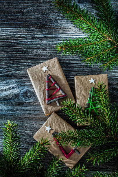 istock Green fir tree branches packed gift box on wooden board 1057129366