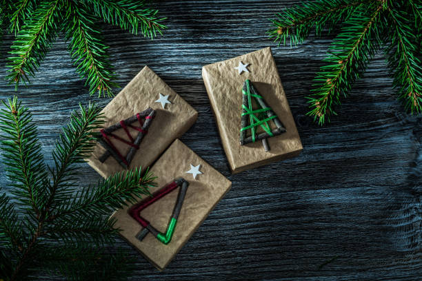 istock Handmade present boxes fir tree branch on wooden board 1057129390