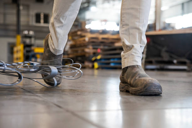 istock An industrial safety topic.  A worker tripping over a poorly placed piece scrap metal in a factory. 1057132628
