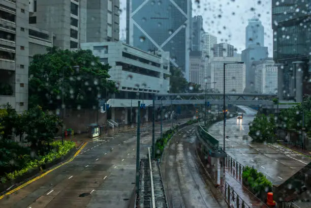 Heavy rain, emty streets and a fallen tree in the empty streets of Hong Kong after a storm - 1