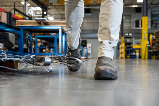 istock An industrial safety topic.  A worker tripping over a poorly placed piece scrap metal in a factory. 1057134528