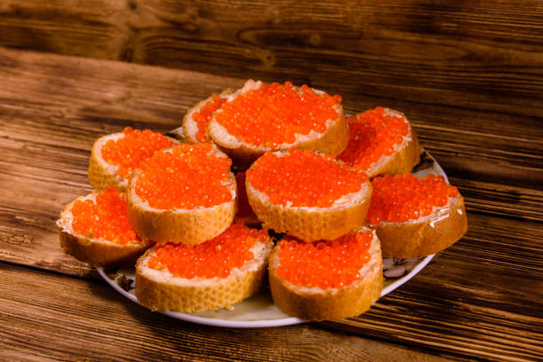 istock Sandwiches with red caviar on wooden table 1057140762