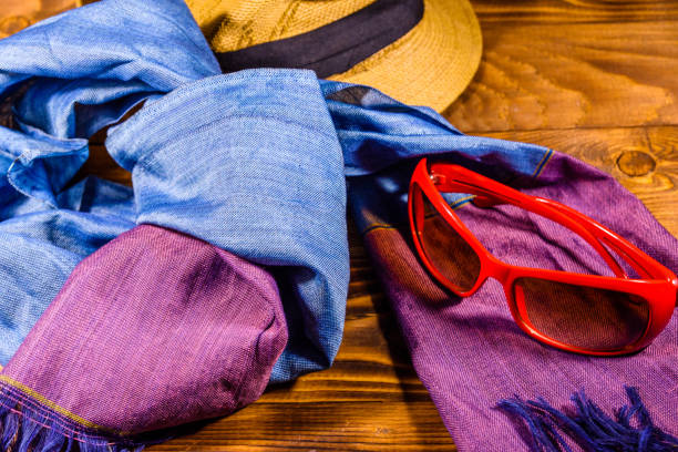 istock Scarf, straw hat and eyeglasses on wooden table 1057140834