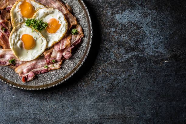 istock Top of view roasted bacon and egg with herbs on plate. 1057143202