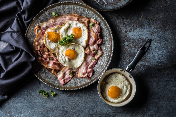 istock Top of view roasted bacon and egg with herbs on plate. 1057143296