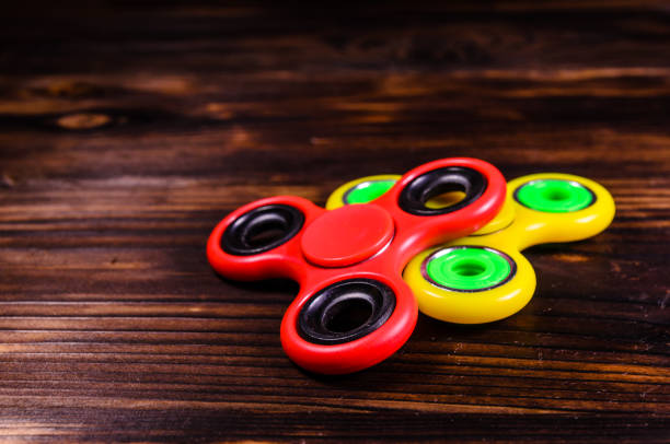 istock Two fidget spinners on wooden desk 1057143398