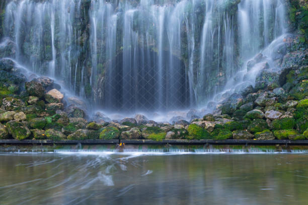 waterfall with beautiful water blur on the background of granite stones covered with green moss