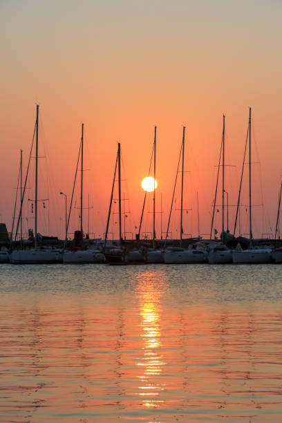 istock Sailing ships at sunrise at Mandraki harbor 1057149362
