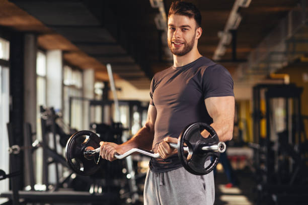 istock Handsome man doing biceps lifting in a gym 1057149450