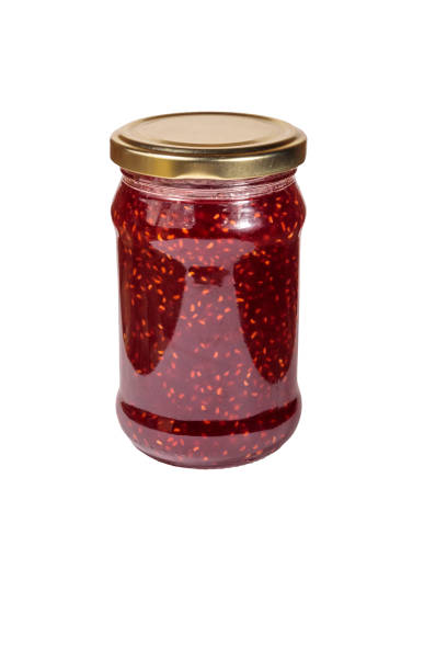 istock Raspberry jam in glass jar isolated on white background 1057149922