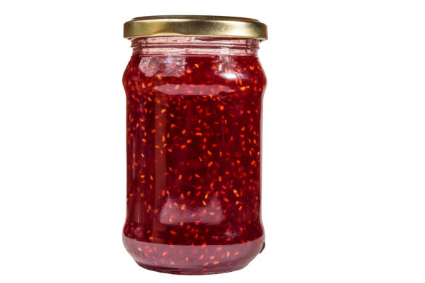 istock Raspberry jam in glass jar isolated on white background 1057149924