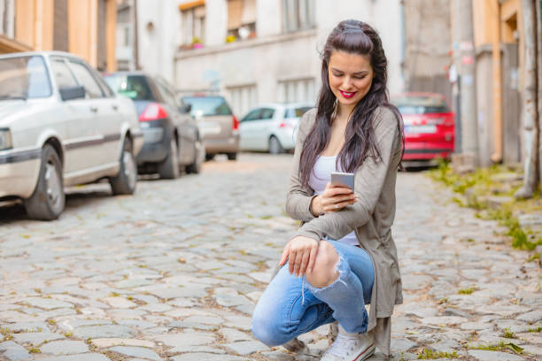 istock Cute young woman using cellphone in urban surroundings. 1057152192