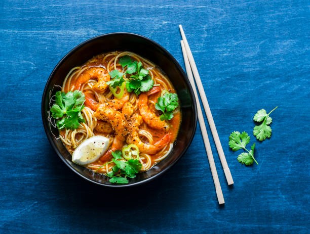 istock Rice noodles with shrimp curry sauce on blue background, top view 1057161170