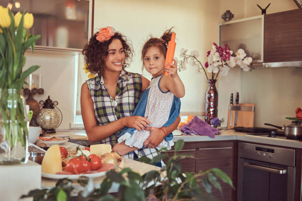 linda mãe hispânica ensina sua filha bonita preparar pizza na cozinha. - stereotypical housewife little girls family domestic kitchen - fotografias e filmes do acervo