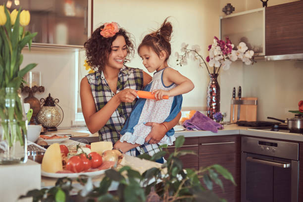 linda mãe hispânica ensina sua filha bonita preparar pizza na cozinha. - stereotypical housewife little girls family domestic kitchen - fotografias e filmes do acervo