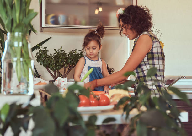 linda mãe hispânica ensina sua filha bonita preparar pizza na cozinha. - stereotypical housewife little girls family domestic kitchen - fotografias e filmes do acervo