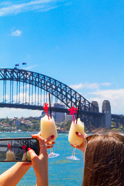 turyści robią selfie i robią okrzyki z koktailami przed sydney harbour bridge - the rocks sydney harbor bridge sydney australia new south wales zdjęcia i obrazy z banku zdjęć