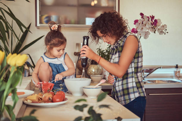 linda mãe hispânica ensina sua filha bonita preparar pizza na cozinha. - stereotypical housewife little girls family domestic kitchen - fotografias e filmes do acervo