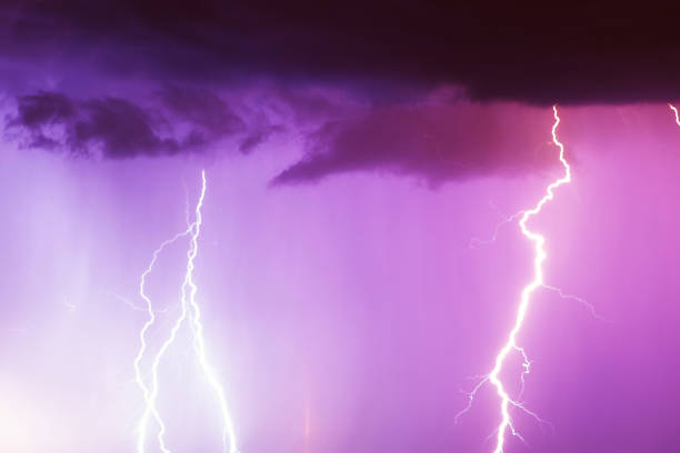 istock Lightning strike on the dark cloudy sky. Pink and purple and red toned image 1057171346