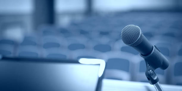 istock Rostrum with microphone and computer in conference room 1057171430