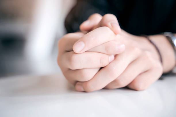 istock close up female hands with fingers together 1057174186