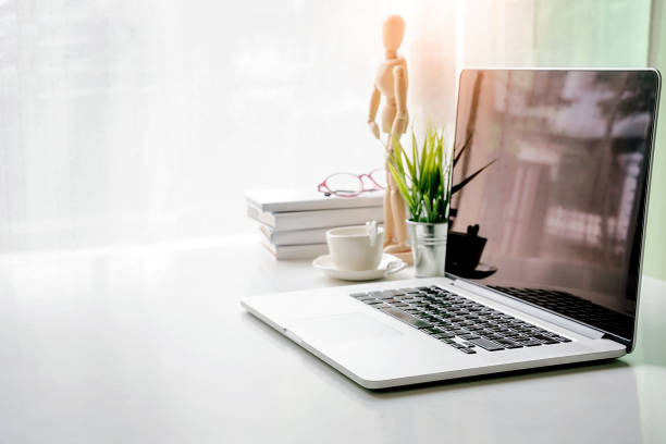istock Mockup blank screen laptop with copy space and office supplies on white desk 1057176794