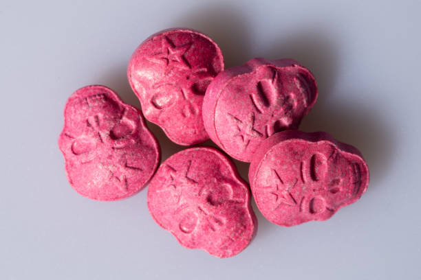 five red army skull, ecstasy, mdma or medication pills shaped like a skull on a grey background. - ecstasy imagens e fotografias de stock