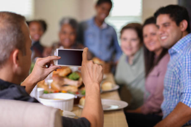 istock Diverse family at dining table eating Thanksgiving dinner. 1057189150