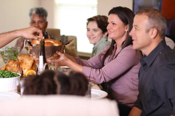 istock Diverse family at dining table eating Thanksgiving dinner. 1057189160