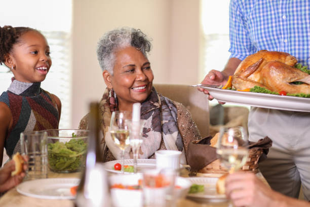 istock Diverse family at dining table eating Thanksgiving dinner. 1057189290