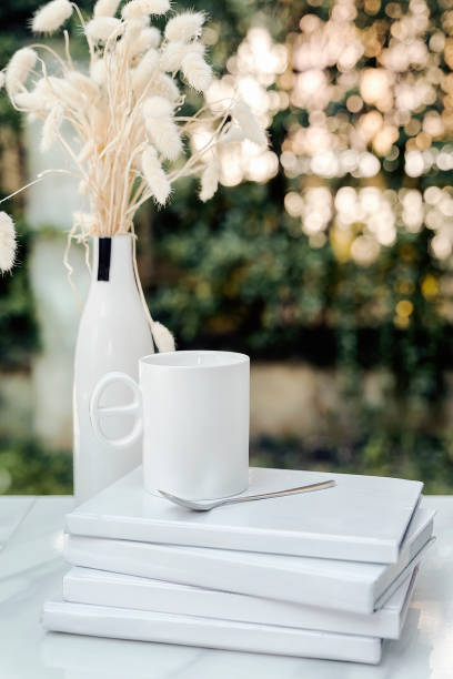 istock White cup and spoon on white books with bokeh of sunlight 1057189368