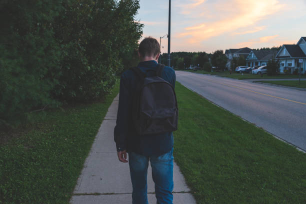 istock Upset teenager walking down a sidewalk at sunset. 1057189542
