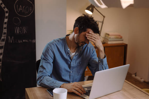 istock man working from his home. late night 1057191988