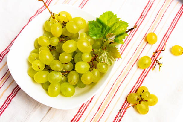 istock Green grapes in a white bowl top view 1057193216