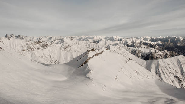 istock Pure white winter mountains covered with snow under the grey cloudy sky 1057196182