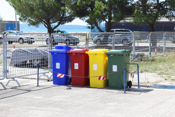 istock Four multicolored boxes for sorted garbage: red, green, blue and yellow. Recycling garbage in the tourist area. Infrastructure of the Mediterranean marina. Plastic waste containers. 1057196196