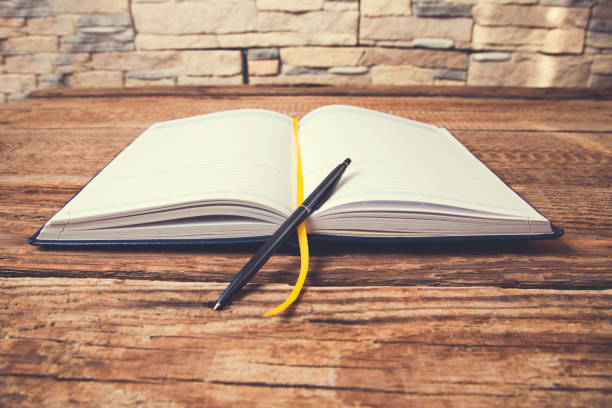 istock pen on notepad on vintage wooden table 1057197602