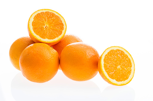 Whole oranges and half orange on white background.