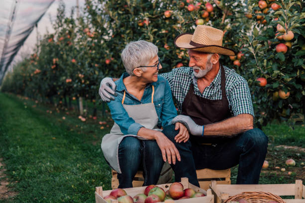 istock Old couple hugging at apple orchard 1057212900