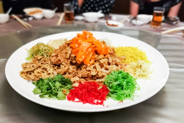 Serving of Yee Sang or Yusheng during Chinese New Year Serving of Yee Sang or Yusheng with raw salmon fish during Chinese New Year, for luck and prosperity cantonese cuisine stock pictures, royalty-free photos & images