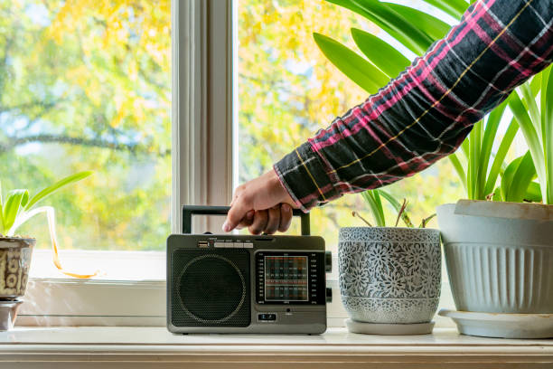 old retro radio with antenna on the window at home playing music f old retro radio with antenna on the window at home playing music old person listening to radio stock pictures, royalty-free photos & images