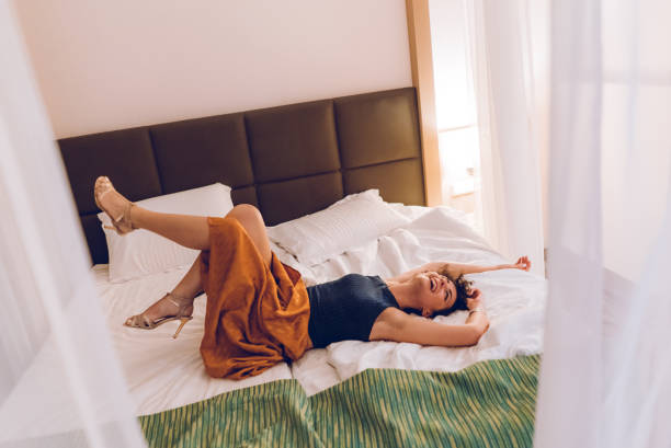 istock Woman on a bed in hotel room 1057231330