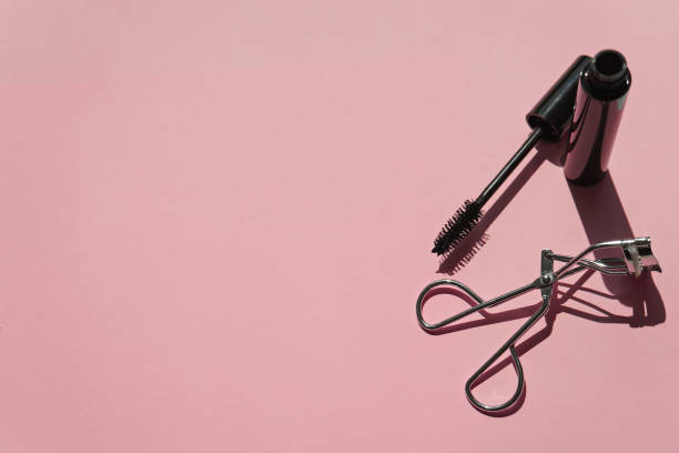 istock Black mascara with curler  on pink  background 1057235522